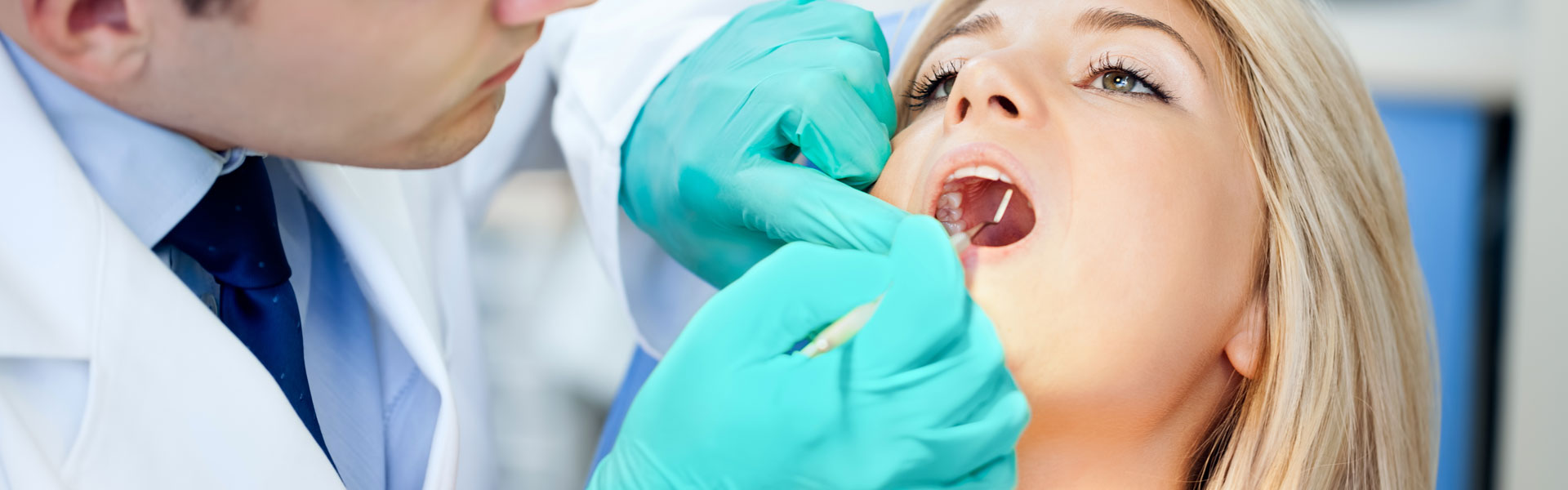 Dentist examining female patient teeth