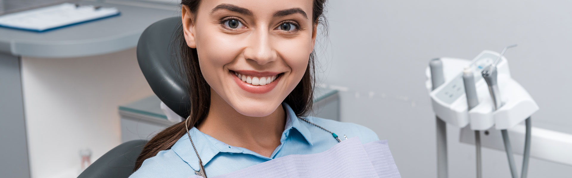 Smiling young woman sitting on dental chair